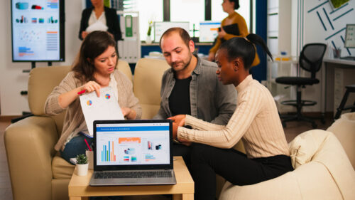 Group of colleagues sit and discuss charts